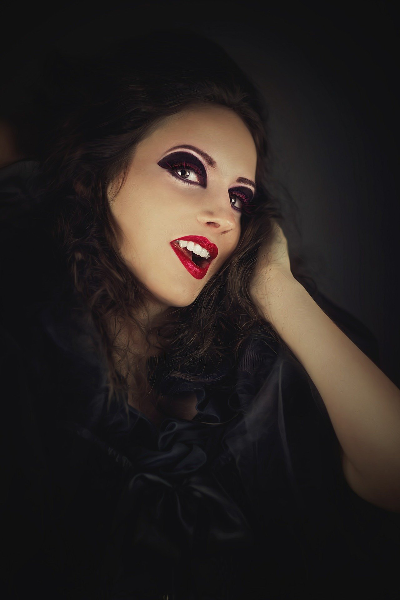 Smiling gothic woman with dramatic eyeliner and bold red lipstick, embodying a playful yet dark vampire vibe.