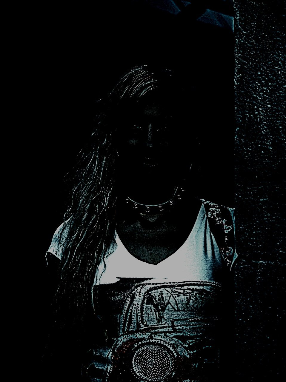 A woman posing confidently in a park setting, with her figure highlighted against the dark blue tones of the evening light.
