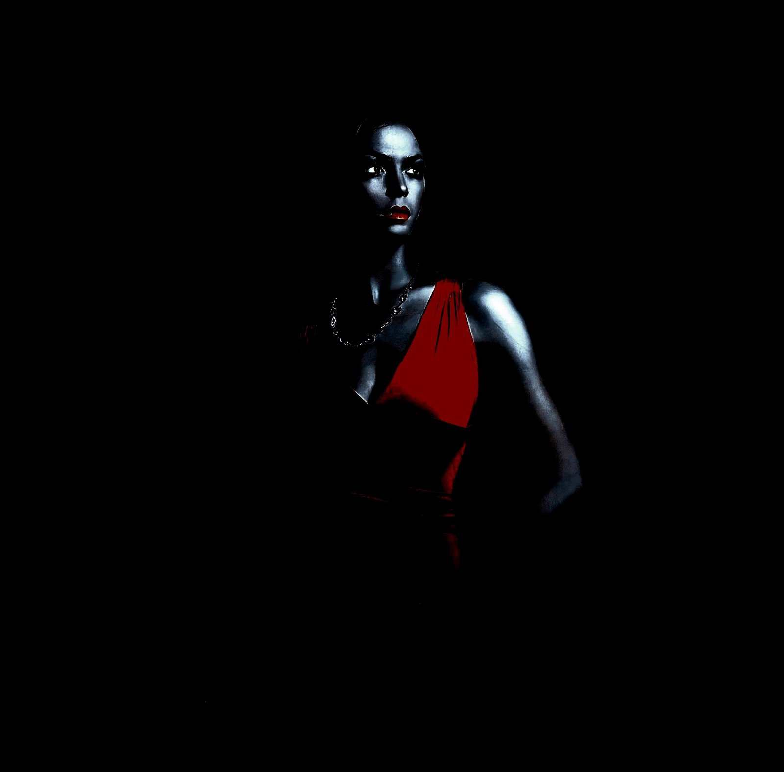 A woman in a red dress standing in a dark space, with her face and upper body dramatically highlighted, emphasizing her confident and intense expression.