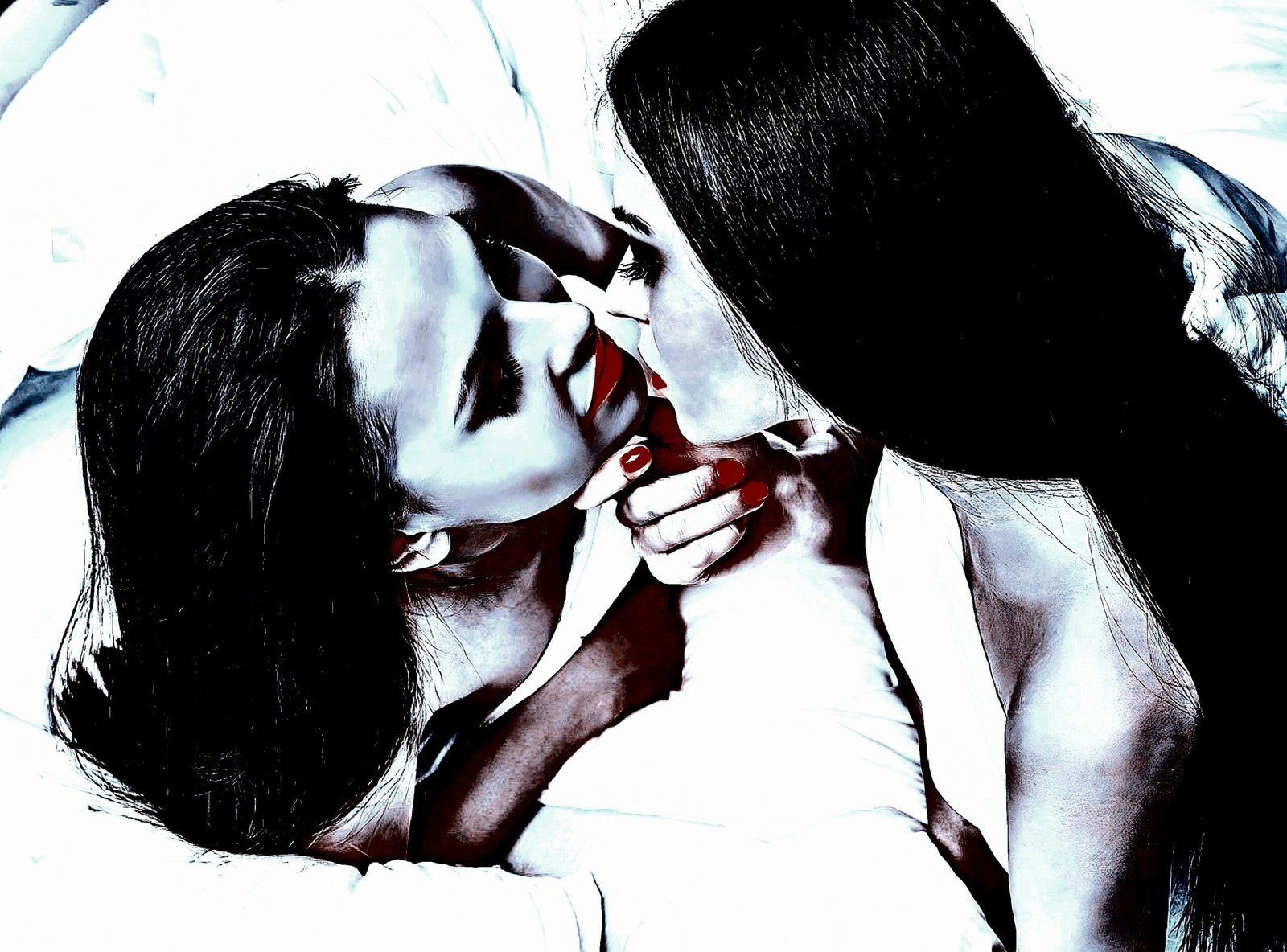 Two women on a bed, sharing a soft, intimate kiss, with gothic-inspired red accents in their makeup.