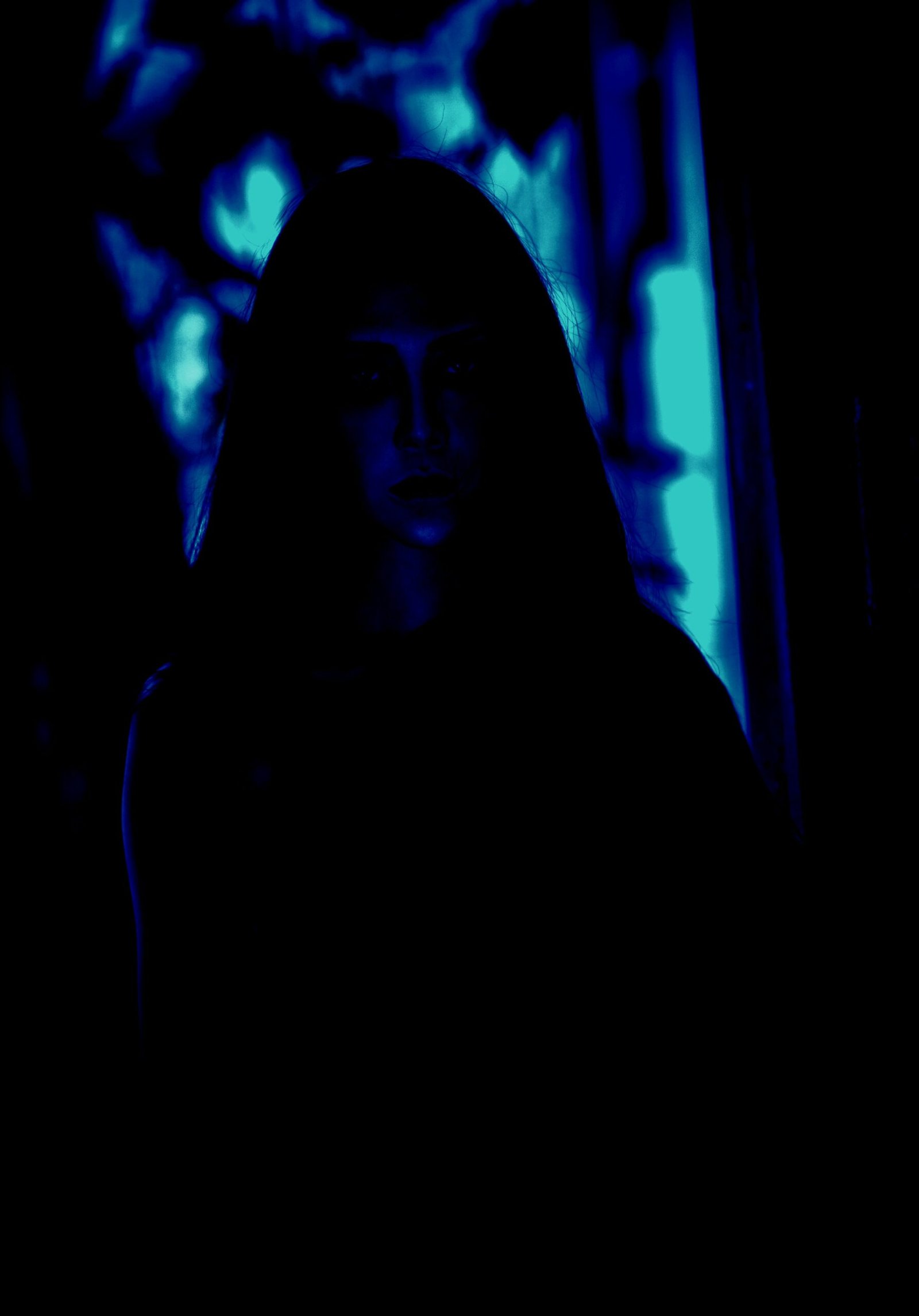 A mysterious figure with long hair, partially obscured in shadows, with a deep blue glow adding to the eerie atmosphere.