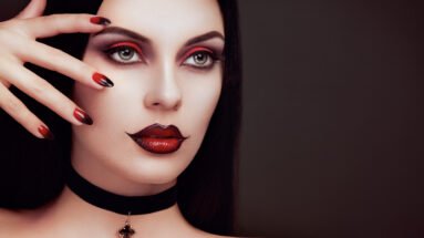 Close-up of a woman with a gothic look, featuring sharp red nails and dark makeup, wearing a black choker with a gemstone pendant.