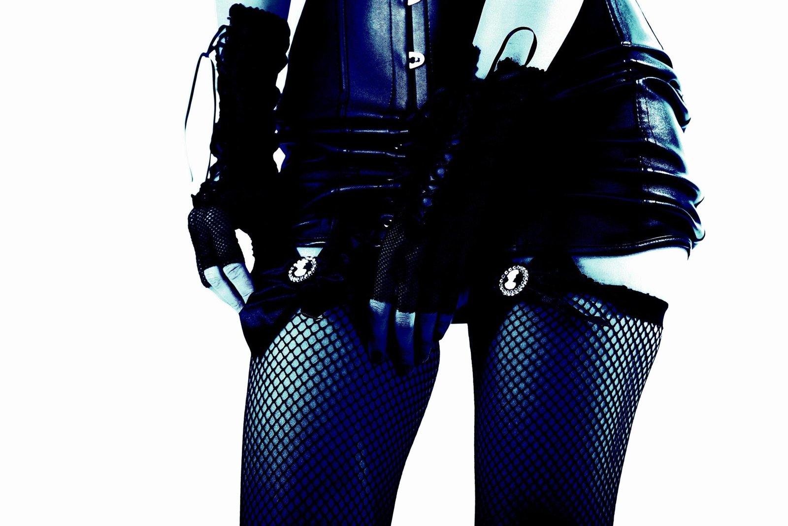 Close-up of a woman in a black leather corset and fishnet stockings, adjusting garter straps for a bold look.