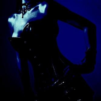 Silhouette of a woman in a tight black corset, exuding elegance and sensuality against a dark background. 