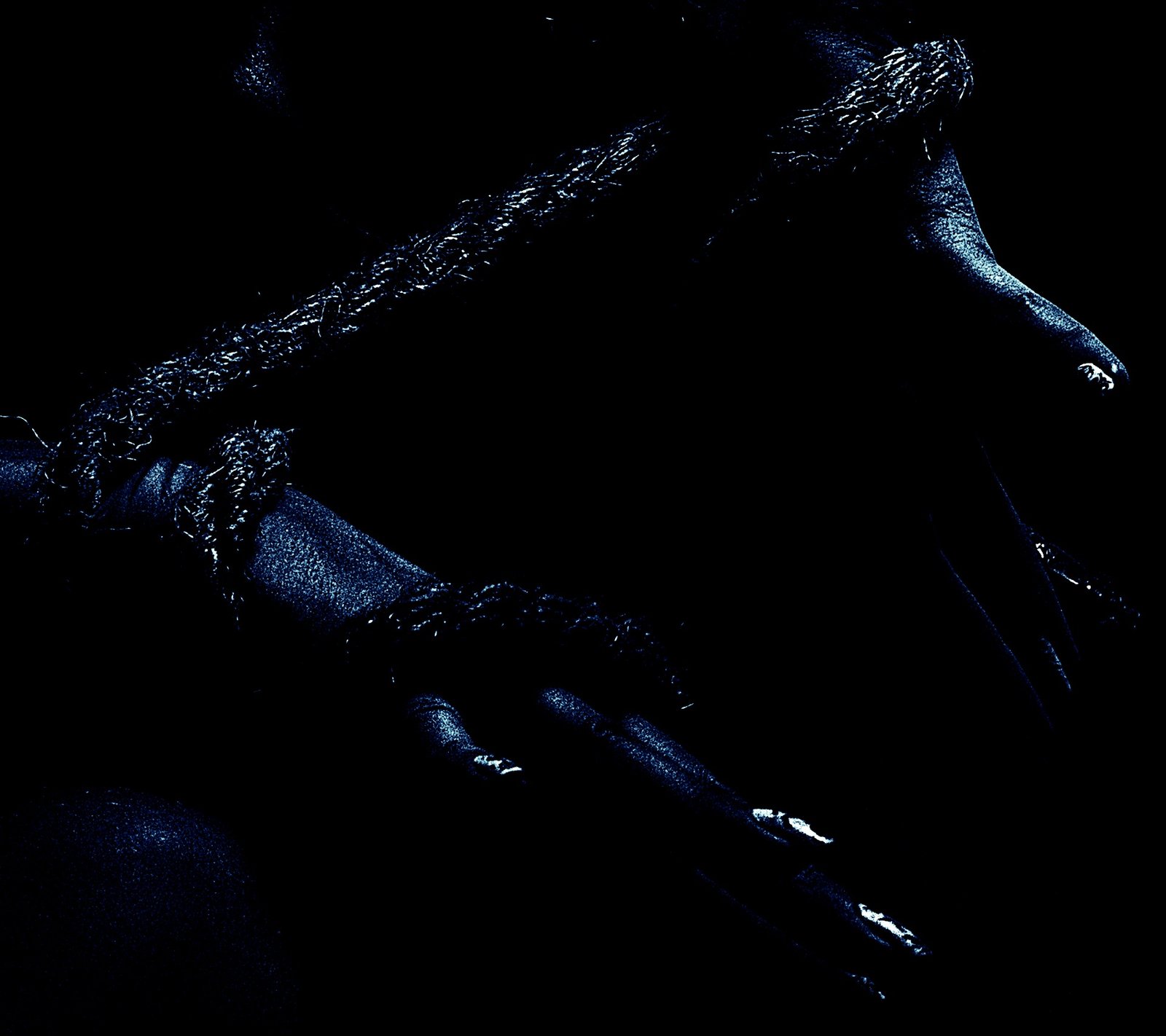 Hands bound tightly with rough rope, fingers slightly curled in a low-light setting.