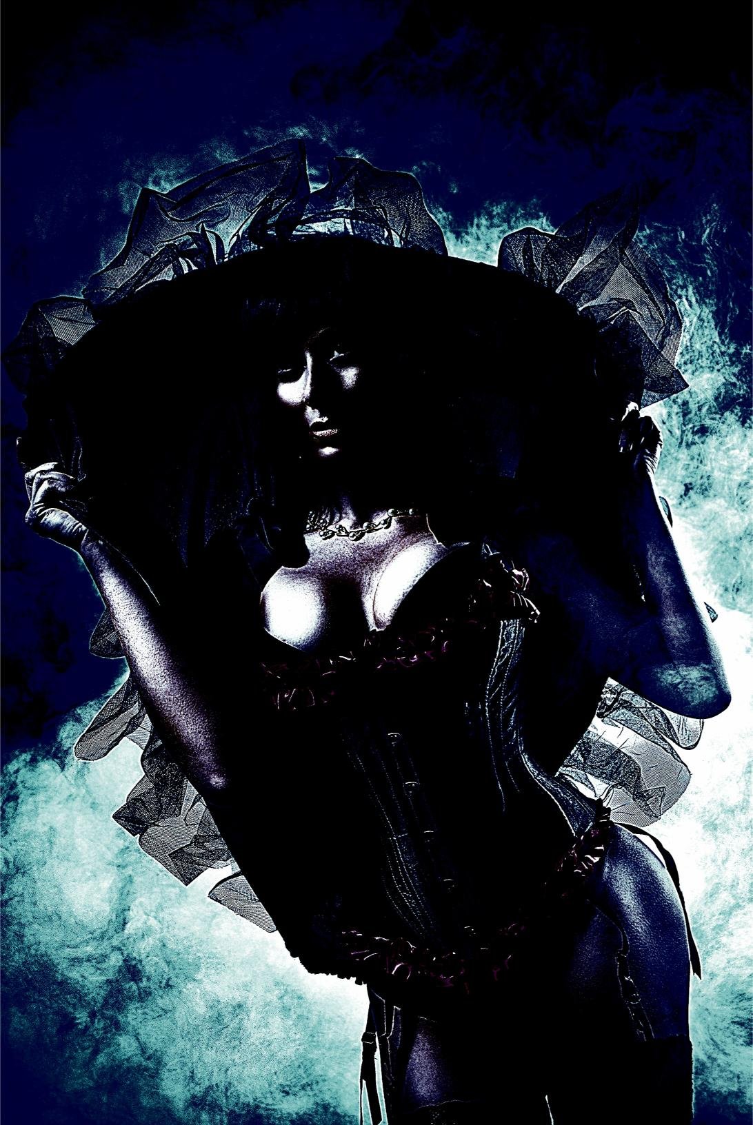 Gothic woman in a dramatic black corset and ruffled veil, holding a large hat against a stormy sky backdrop.