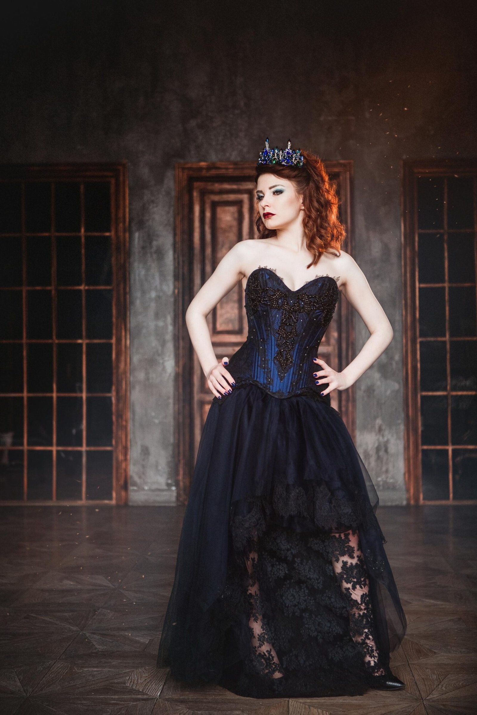 Redhead gothic queen in dark corset dress and crown, regal and defiant