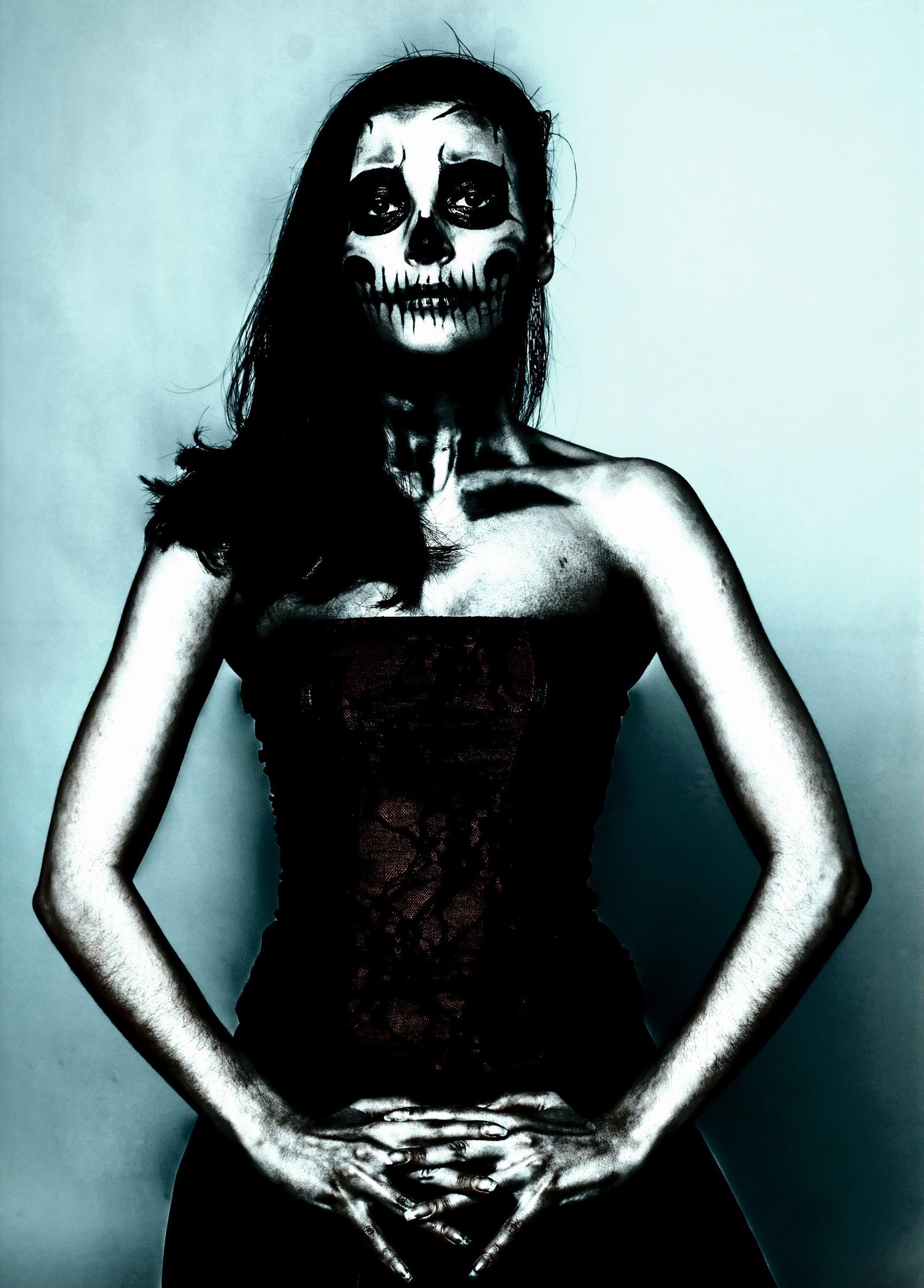 A woman wearing a gothic corset with skeletal face paint, exuding dark, eerie elegance.