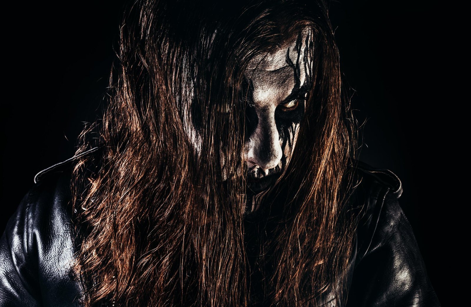 Close-up of black metal artist with corpse paint and intense glare