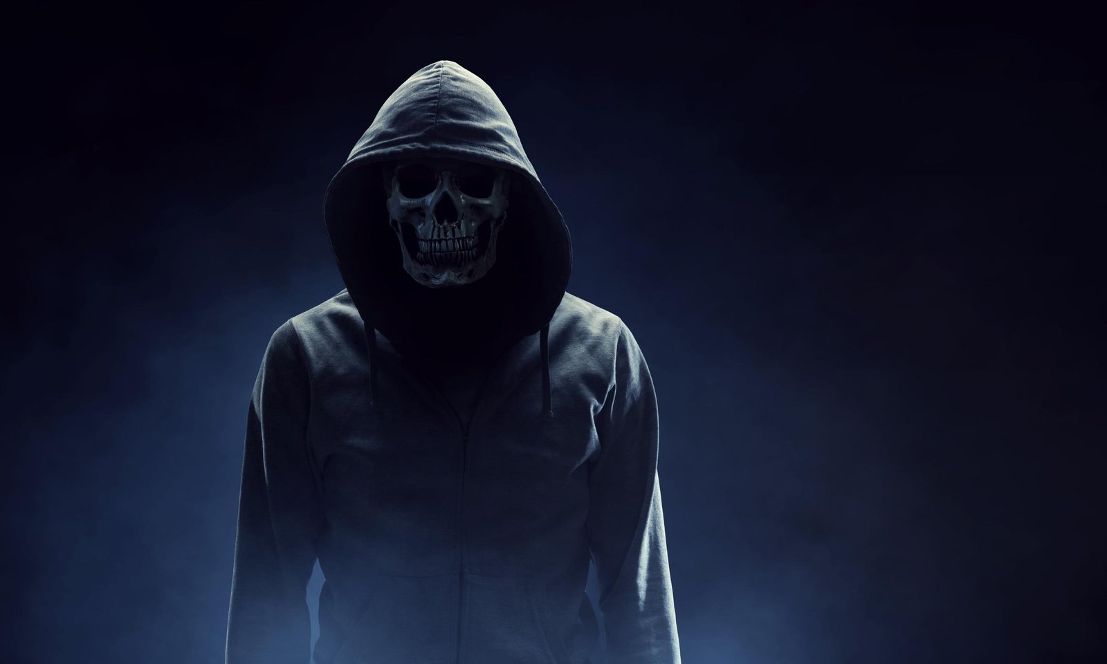 Hooded figure with skull face in eerie fog, symbol of rebellion and death