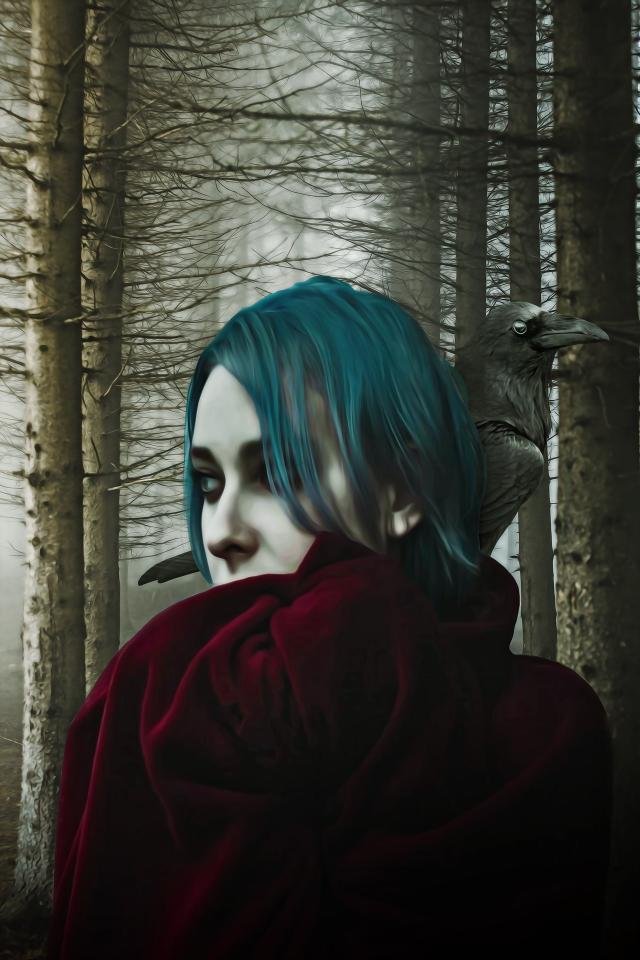 Pale woman with teal hair wrapped in a red cloak, standing in a foggy forest with a raven perched behind her shoulder.
