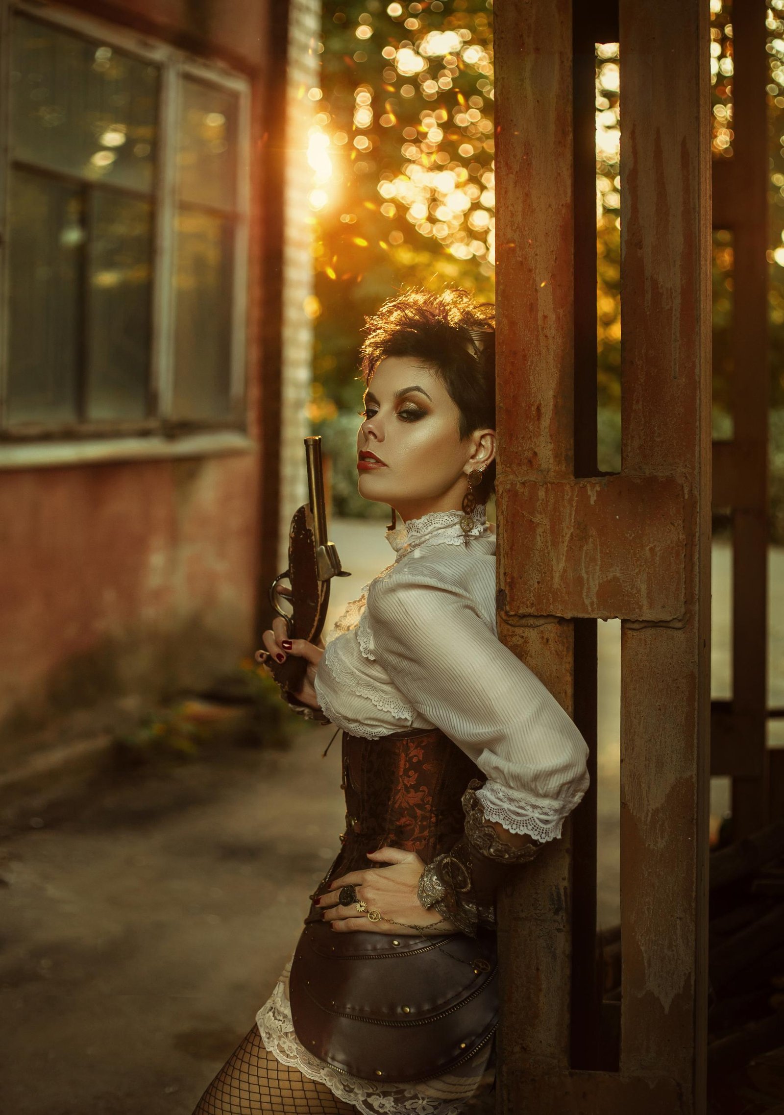 Steampunk-inspired woman leaning against a wall in a brown corset, holding a vintage pistol at sunset.