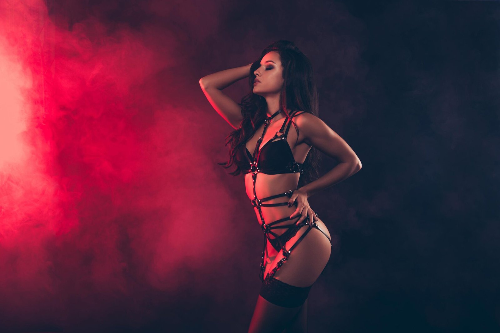 Woman wearing a strappy black corset-inspired harness, showcasing body contouring and dramatic silhouette
