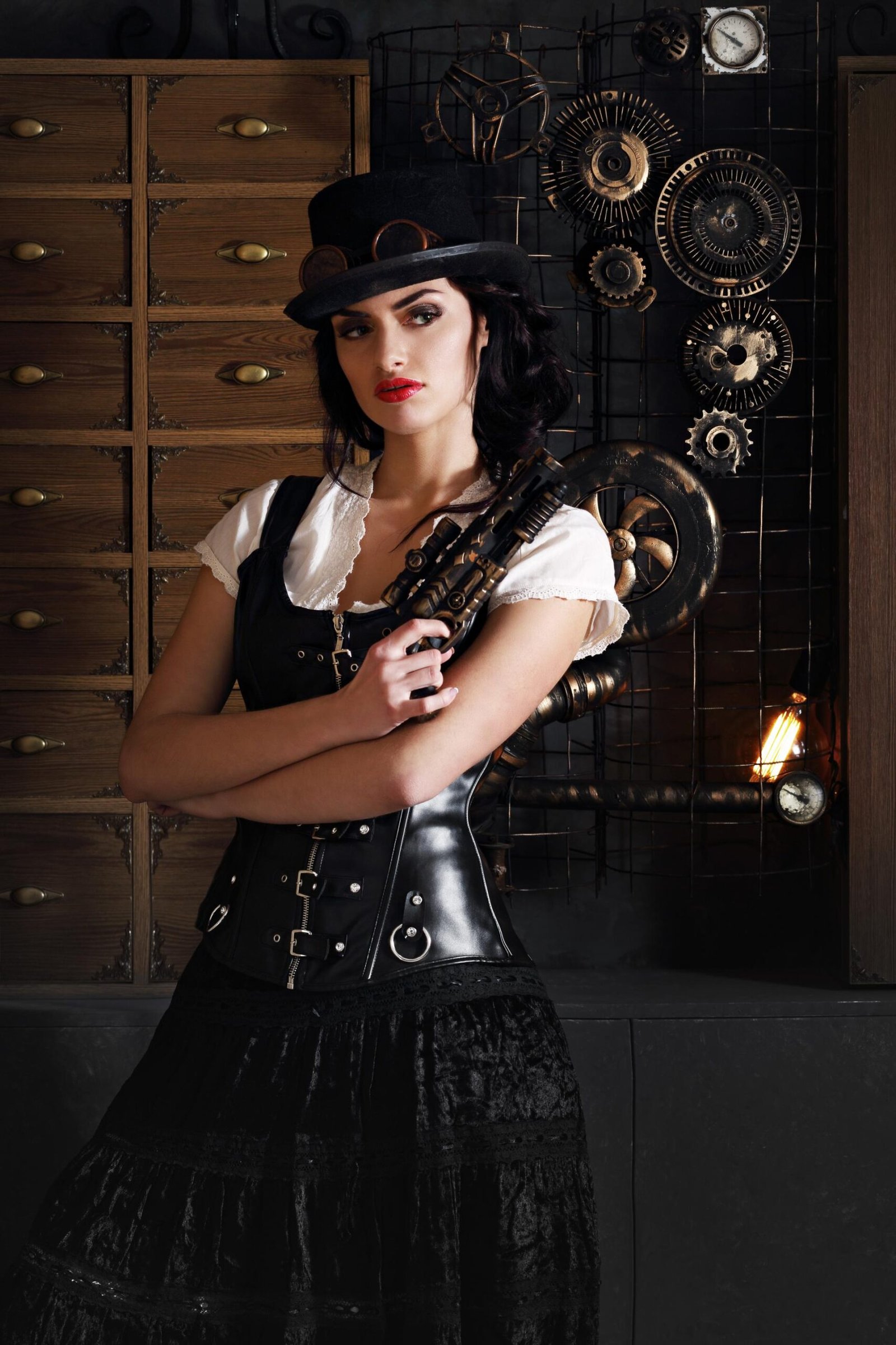 Woman in steampunk-inspired outfit holding a vintage-style gun, standing before mechanical decor